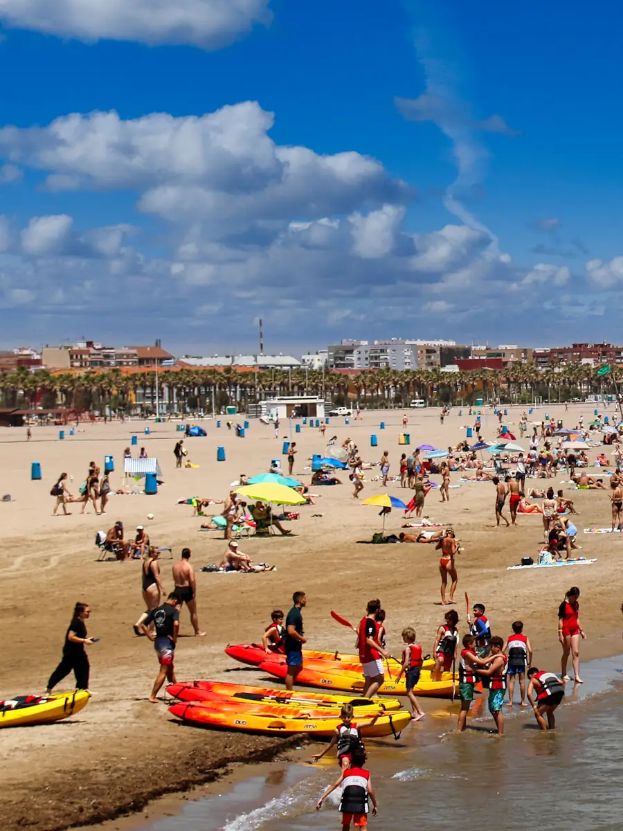 La playa de la Malva-rosa llena de gente, con los edificios del paseo marítimo al fondo